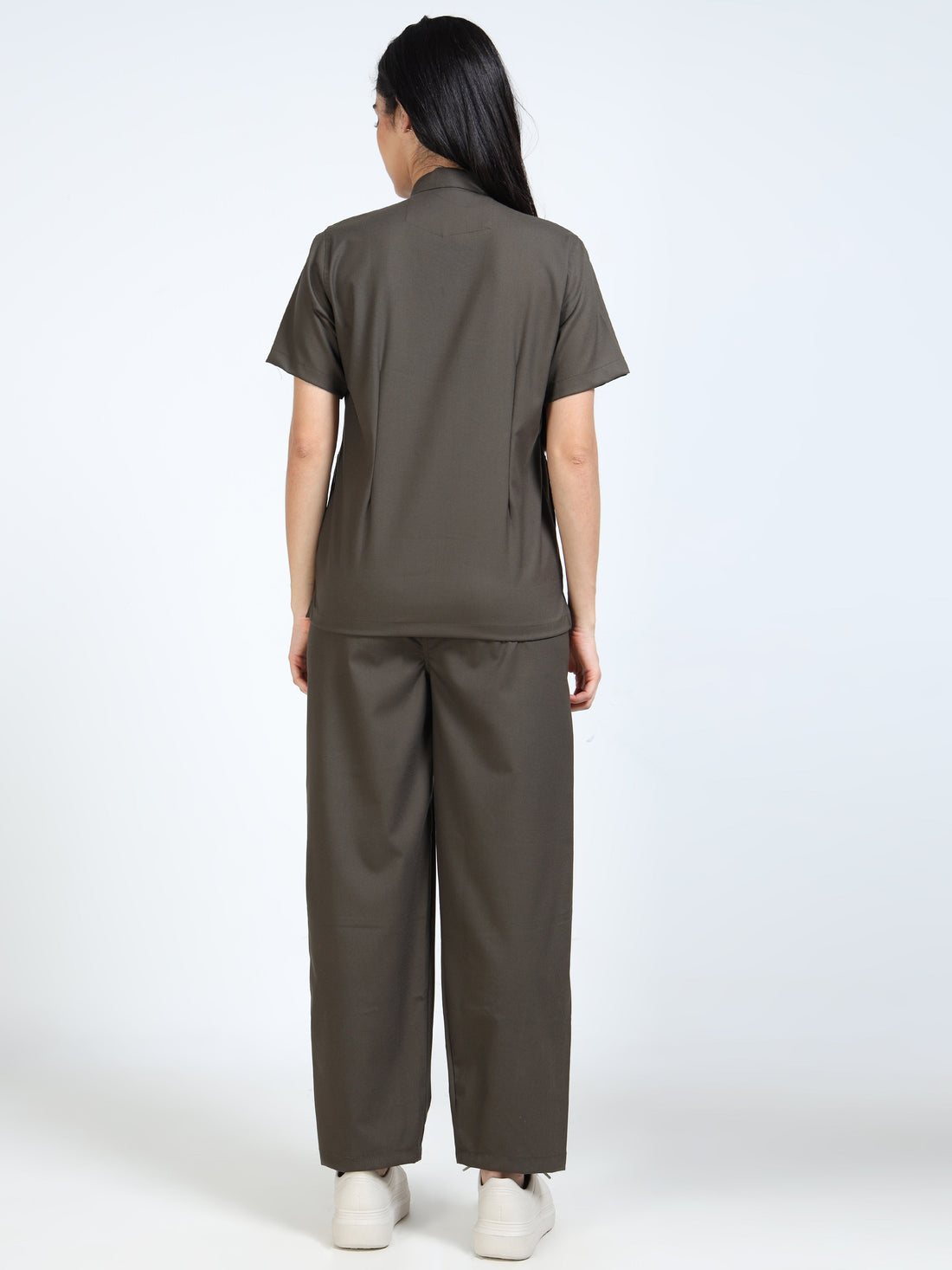 Woman carefully folding clean Mandarin collar medical scrubs after washing